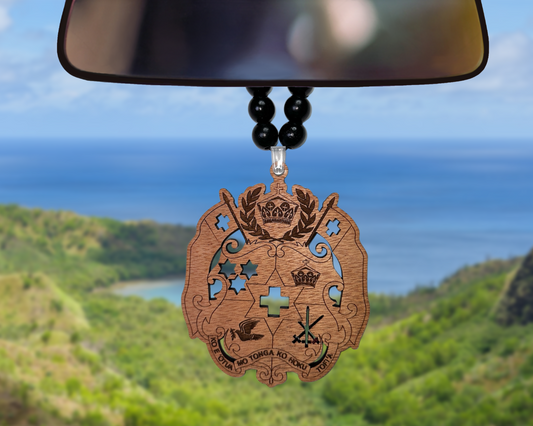 Car mirror with decorative pendant against a scenic background